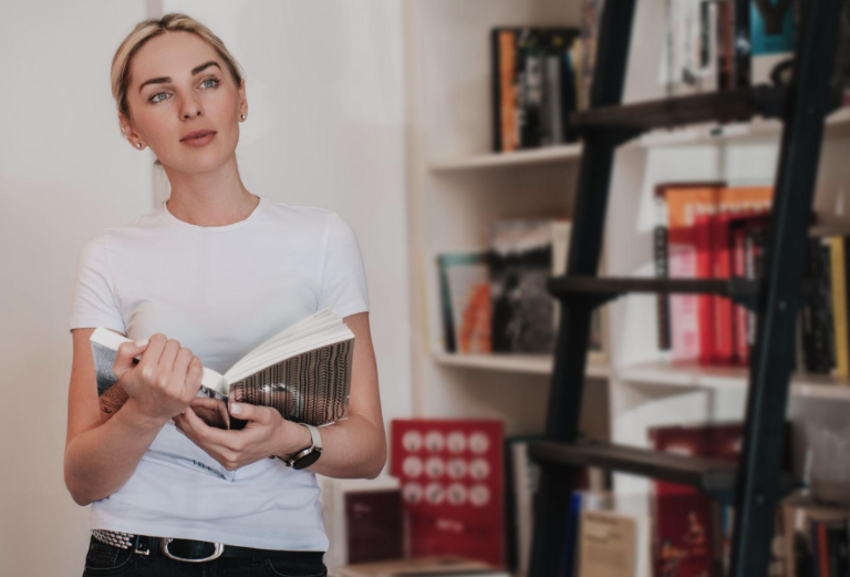 An author reading her own work beside a bookshelf ladder