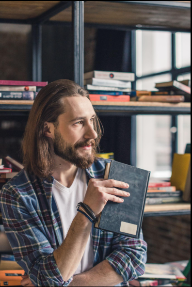 An independent author holding a treasured notebook in his home library