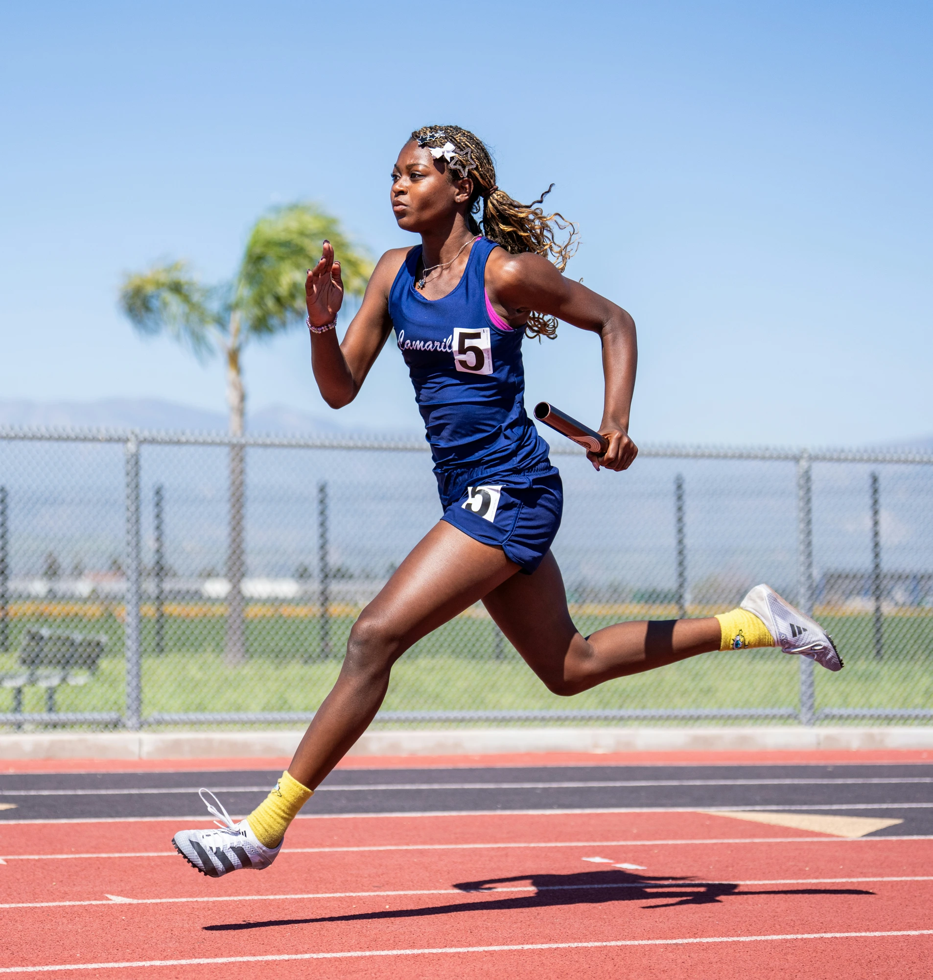 African female sprinter running with baton