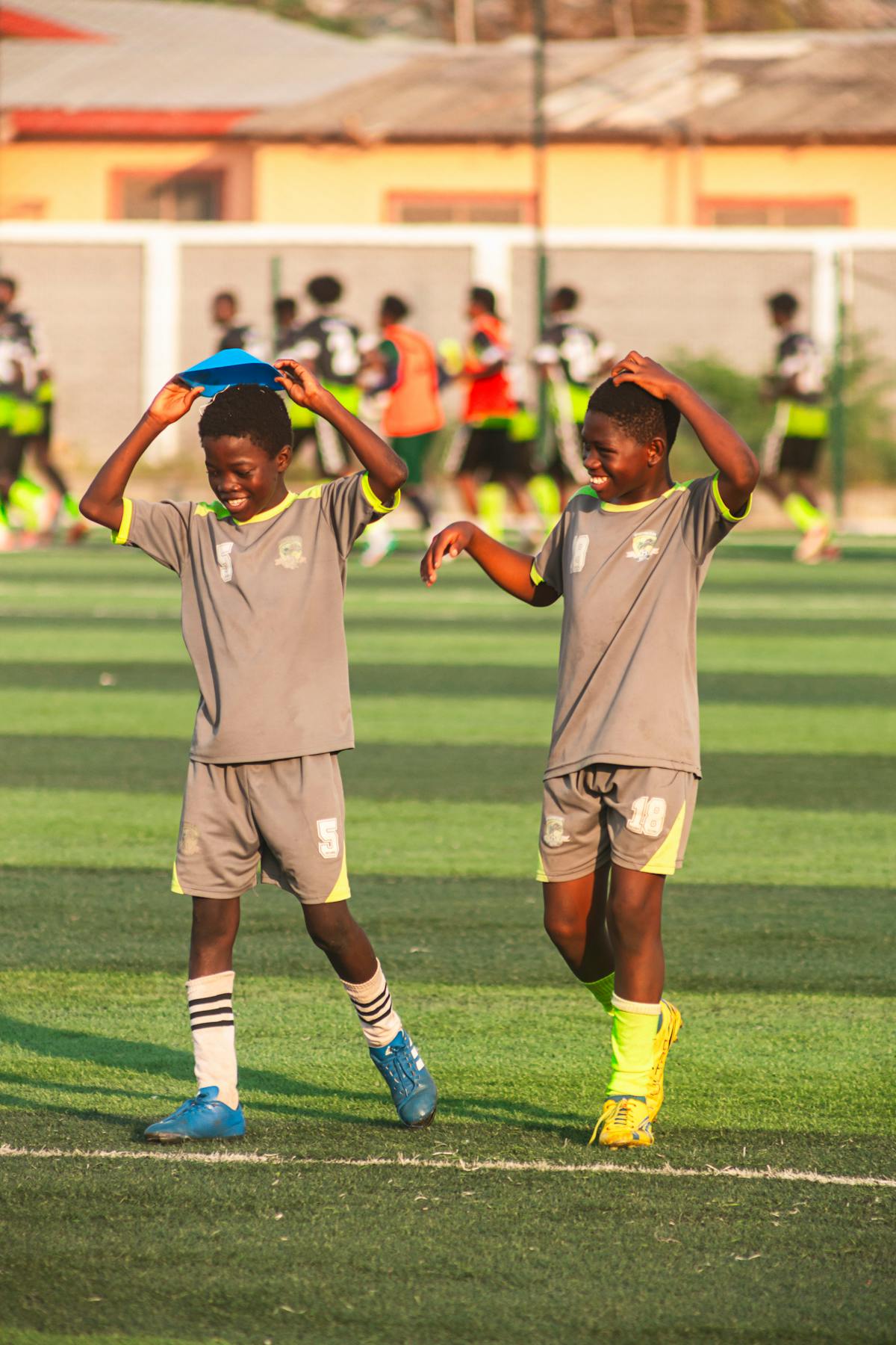 Two young footballers celebrating on the pitch