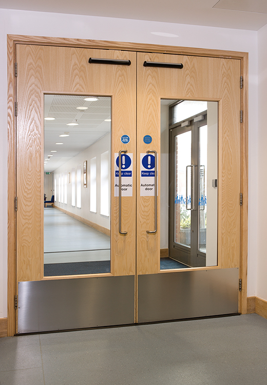 Double timber fire doors with vision panels and safety signage