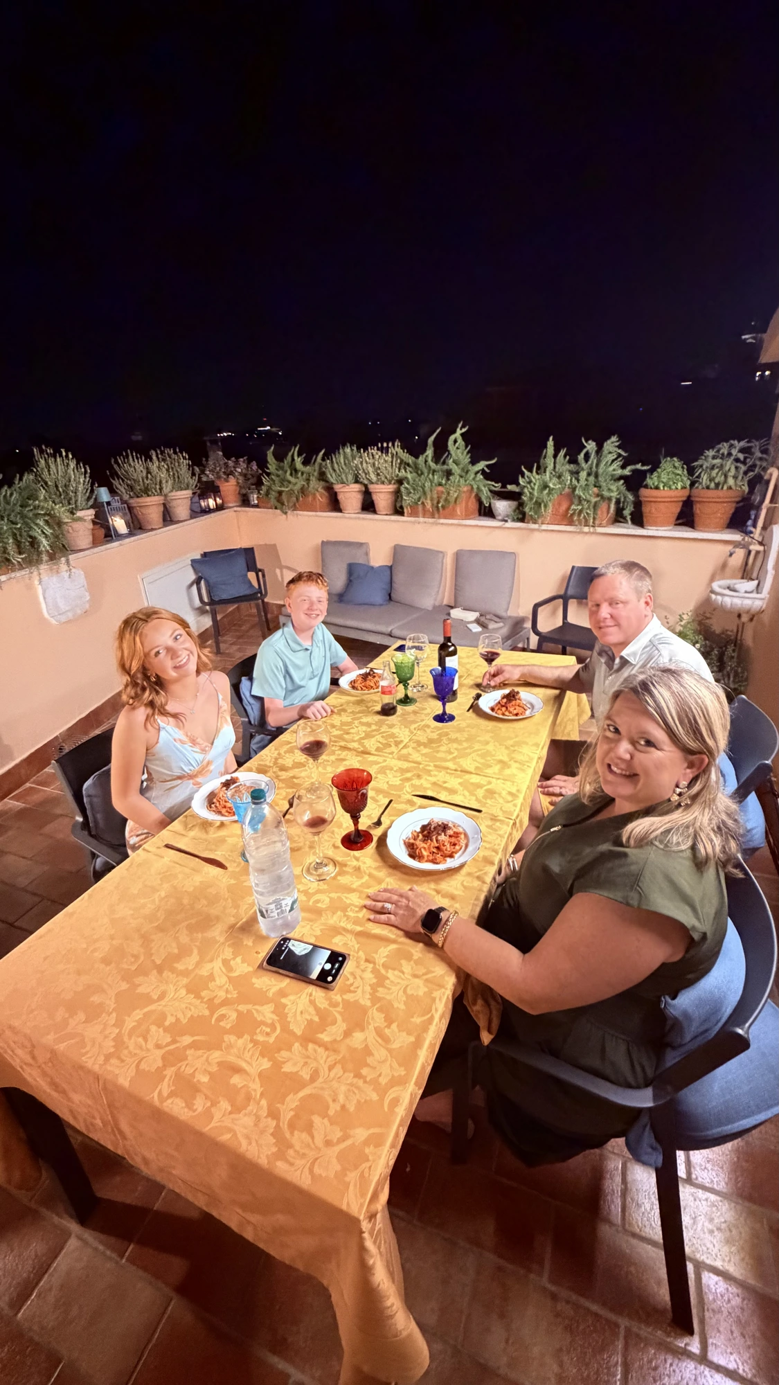 Famiglia a cena sul terrazzo con piatti di pasta