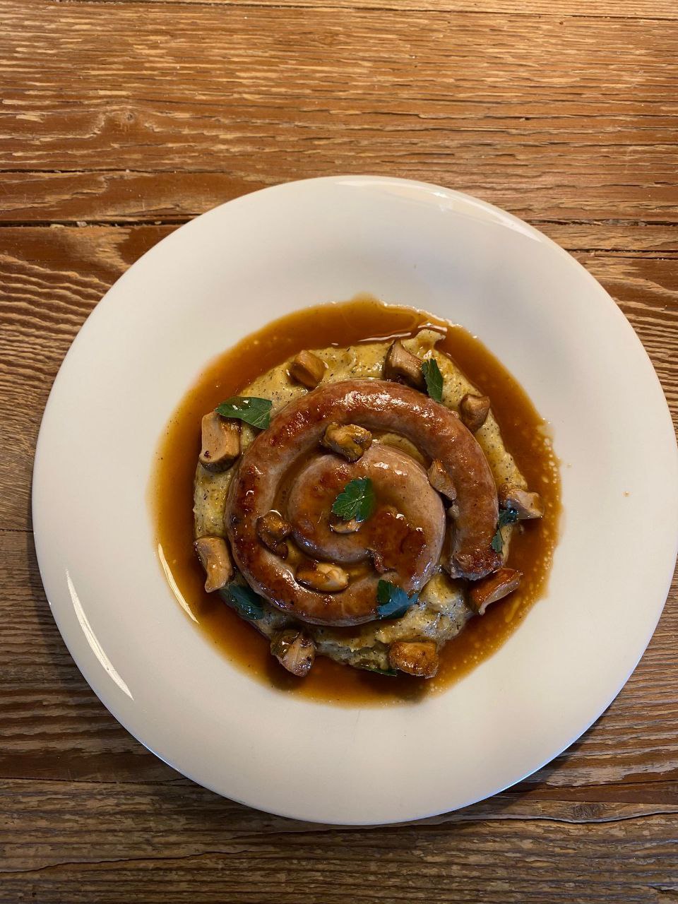 Spirale di salsiccia, polenta cremosa e funghi porcini